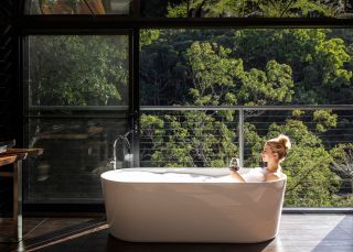 Woman relaxing in the bath with views at Spicers Sangoma Retreat, Bowen Mountain